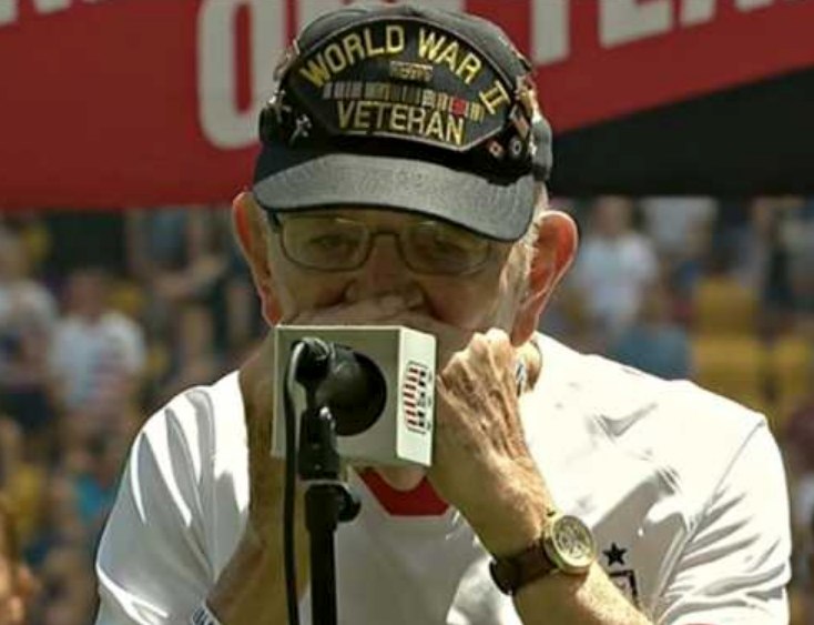 Humble 96-year-old WWII veteran brings stadium to tears with harmonica anthem